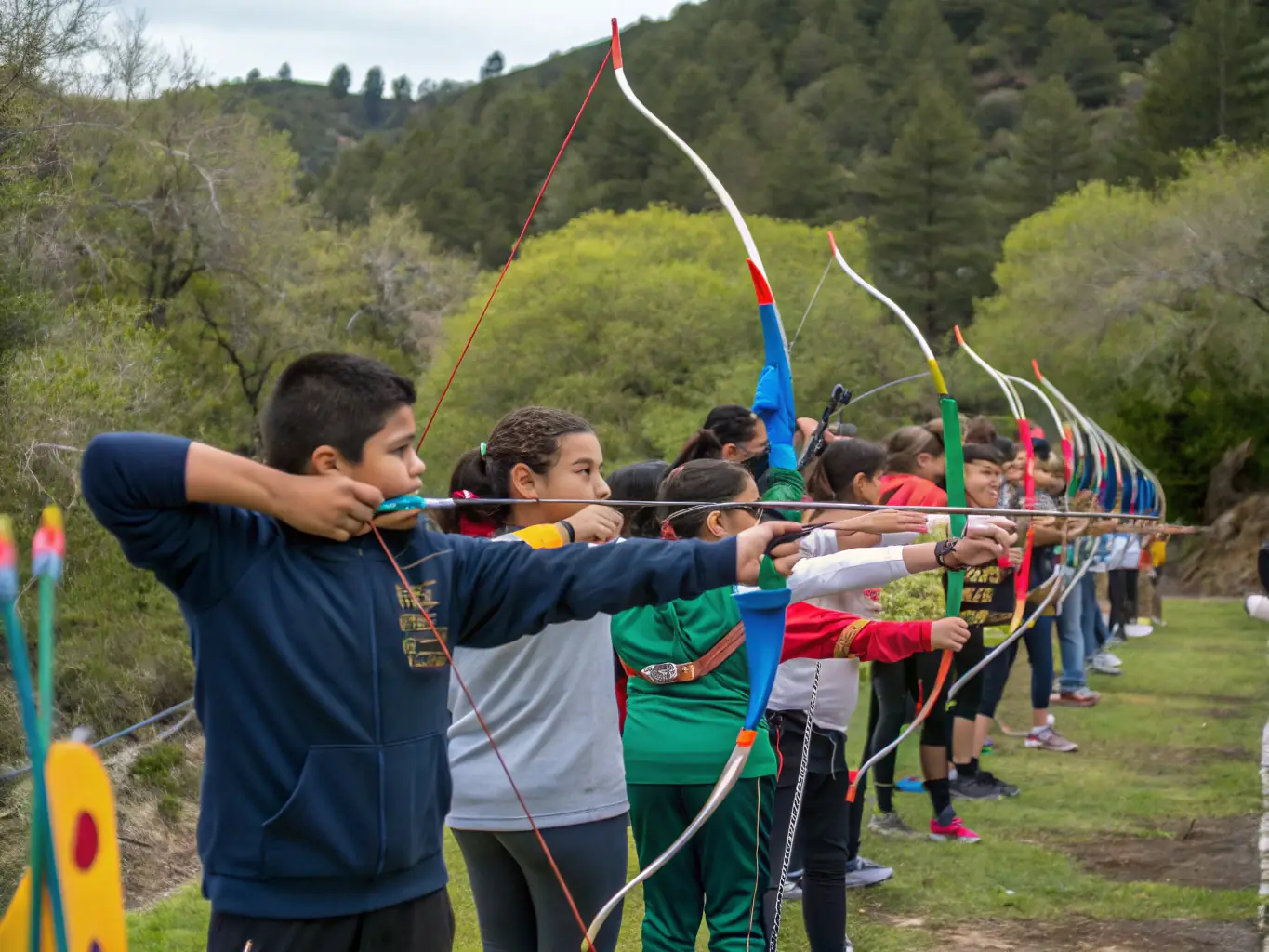 A group of young archers participating in a beginner's archery class at Massilia Arc Club, focusing on basic techniques and safety procedures, with a qualified instructor providing guidance.